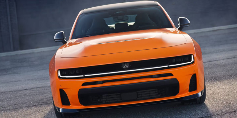 Orange Dodge Charger Daytona parked on an asphalt lot.